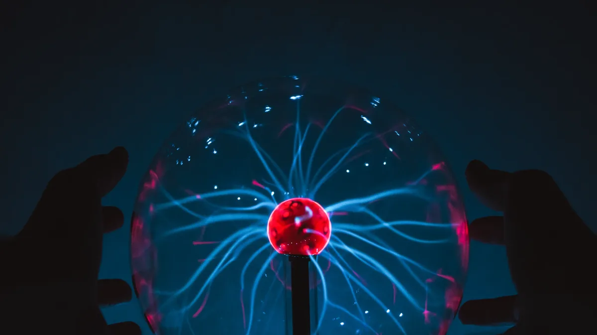A plasma ball, a glass sphere containing a gas that is ionized by high voltage, creating a visible electric discharge.
